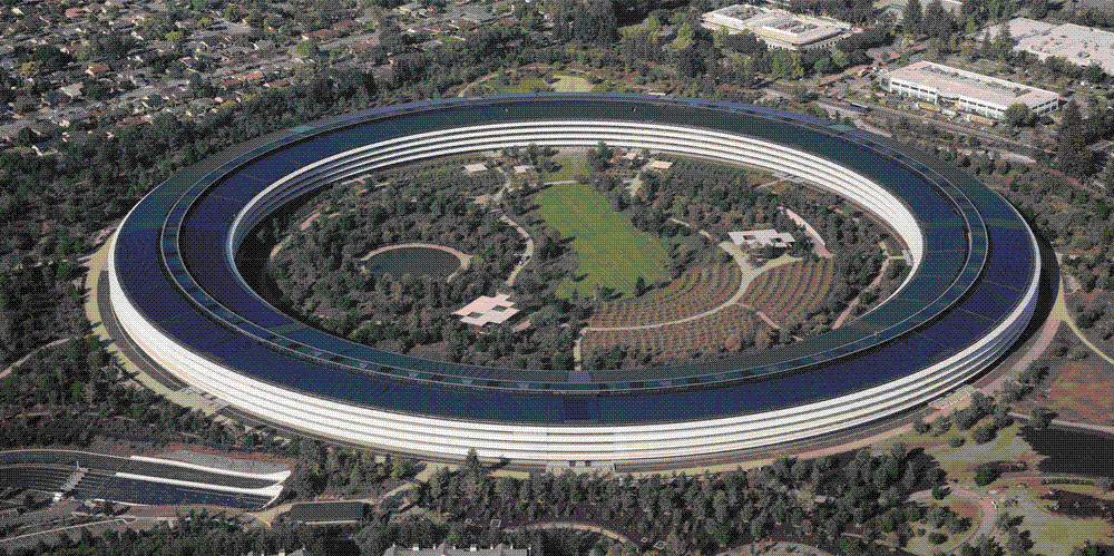An aerial view of Apple's circular glass headquarters building set in landscaped grounds in Cupertino, California.
