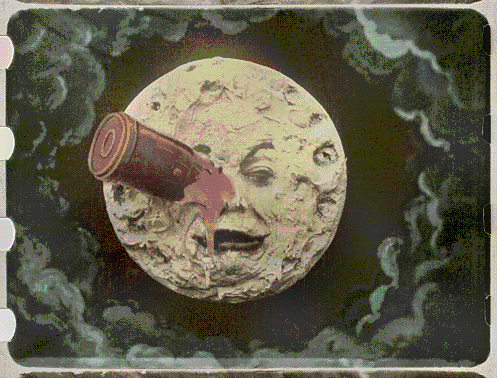 Hand-coloured film frame showing a pale yellow moon with a wrinkled human face; a red bullet-shaped capsule is embedded in its right eye and a bright red splash runs down the cheek, against a background of green painted clouds, with film sprocket holes at the edges.