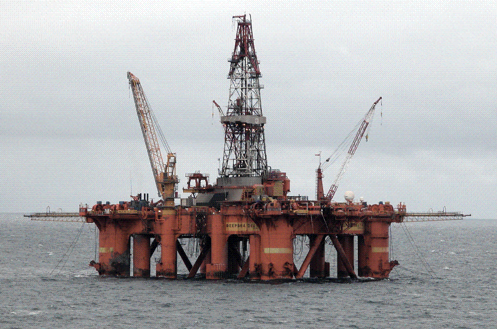 An offshore oil production platform standing on steel legs in open grey water in the North Sea.