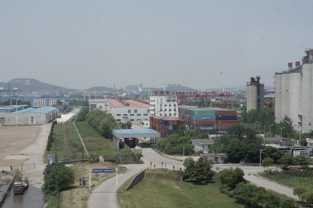 Rows of stacked shipping containers and gantry cranes at Wuhu Port on the Yangtze River in Anhui province, China.