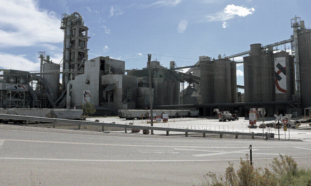 A Holcim cement plant at Portland, Colorado, its kilns, storage silos and conveyors standing against a dry western landscape.