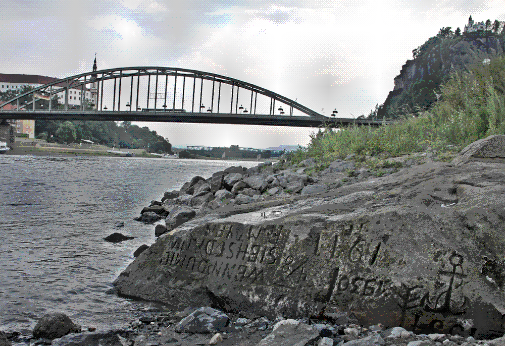 A large inscribed stone exposed above the low water of the Elbe river at Děčín during the drought of summer 2015