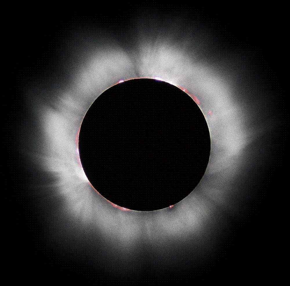 The sun's glowing white corona streaming around the black disc of the moon during a total solar eclipse against a dark sky.