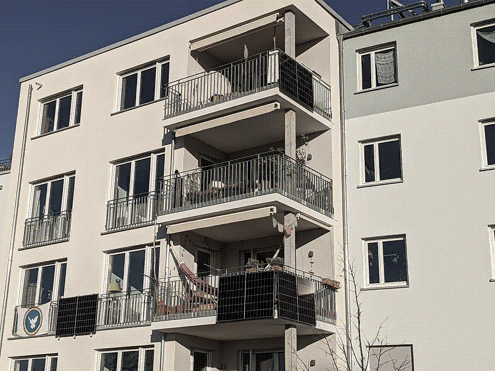 Plug-in solar panels mounted on an apartment balcony railing.